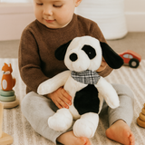 Toddler playing with Buster the Puppy soft toy by Lily & George in a softly styled nursery