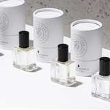 Four The Perfume Oil Collection Gift Set - Floral bottles from The Perfume Oil Company sitting on a white surface emitting a captivating fragrance.