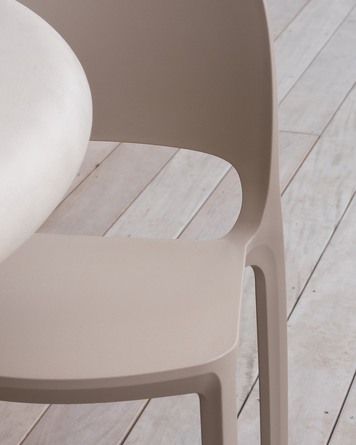 Close up of the matte polyurethane finish where the Cali Chair back meets the seat, in Nude