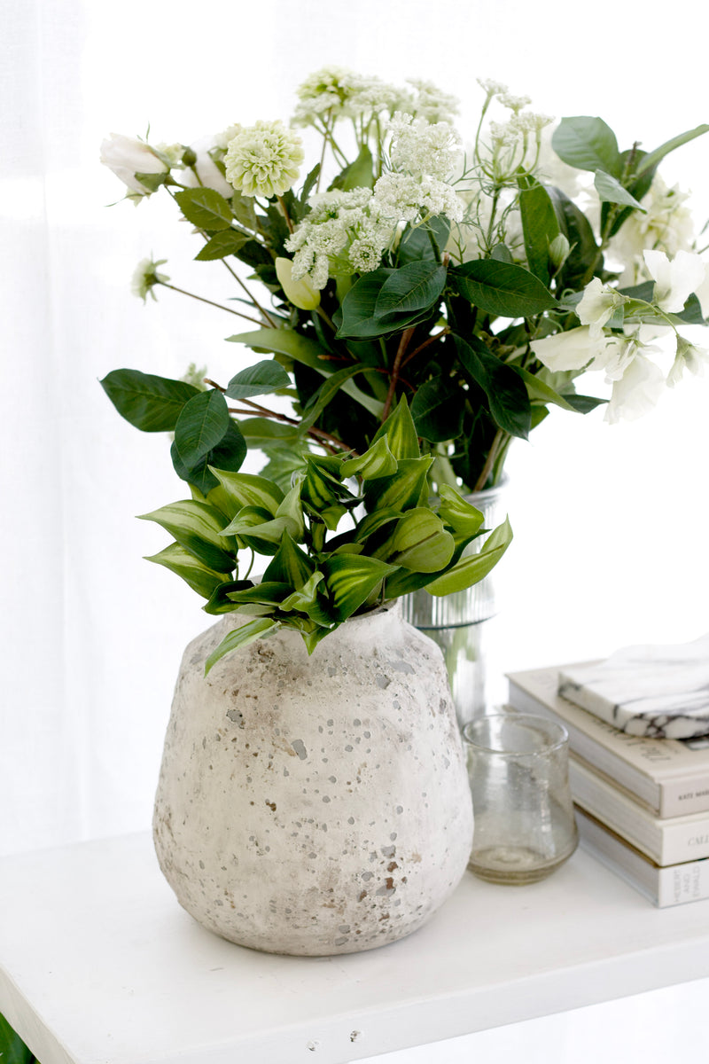 Caspian Rustic Vase with stone-look ceramic finish styled on console with greenery, books, and coastal-inspired accents.