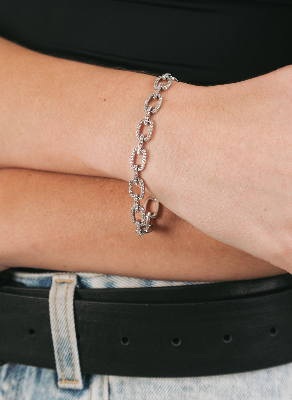 Chained Bracelet worn on a crossed wrist above a black belt and pale denim