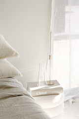 Chloé Catwalk hardback fashion book styled on neutral bedside with candle and glass vase