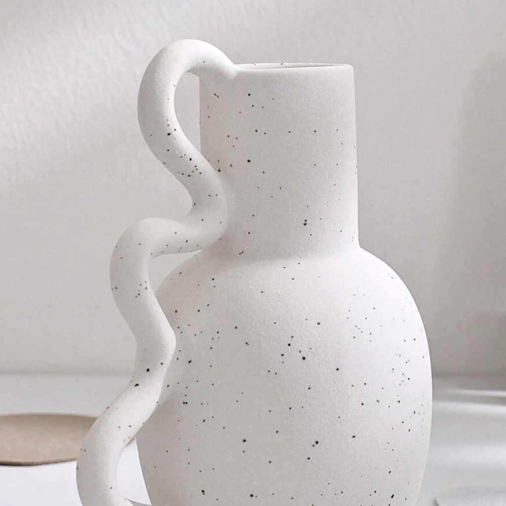 Close view of the speckled Chloe vase and the curve of its squiggle handle