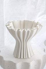 Close-up of the Cleo 3D Printed Compote Vase in white, showcasing the sculptural pleated ridges and ruffled rim against a soft white draped backdrop, matte ceramic finish.
