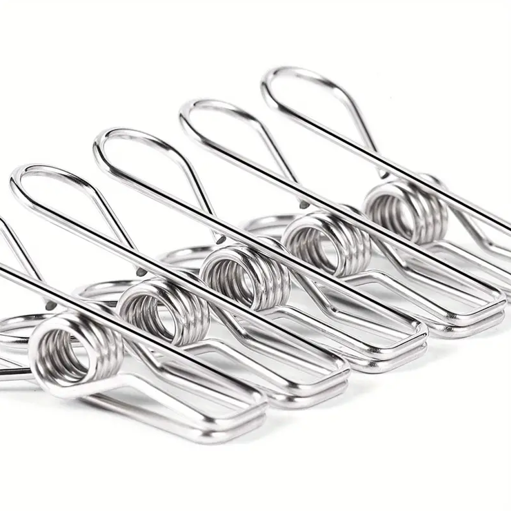Row of stainless steel clothes pegs lined up on a plain white background