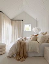 White Cloud Pendant paper lamp shade above layered neutral bedding in a calm Scandi bedroom