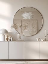 White Cloud Pendant paper lamp shade by a round mirror and styled console in a neutral entryway