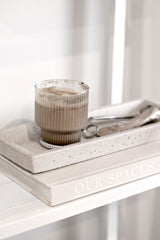 White concrete square tray styled with glass cup and book on minimalist shelf