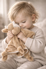 Child holding a plush toy in a cozy setting