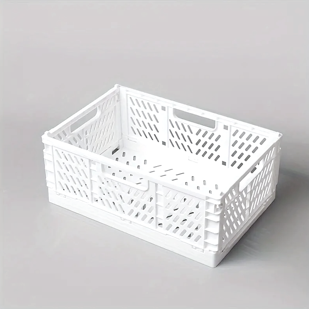 White folding crate photographed at an angle on a grey surface