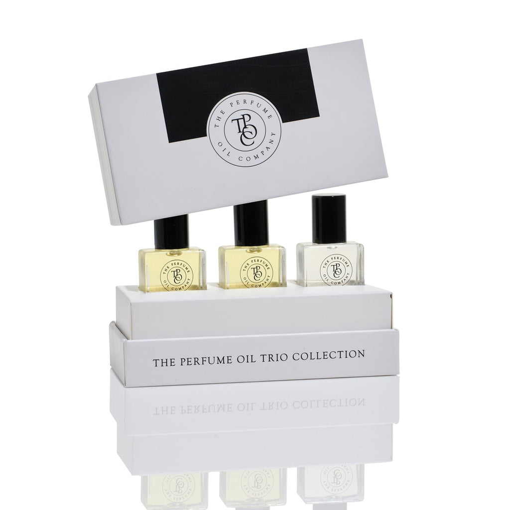 The Perfume Oil Company trio collection box holding three roll-on bottles, with the lid behind