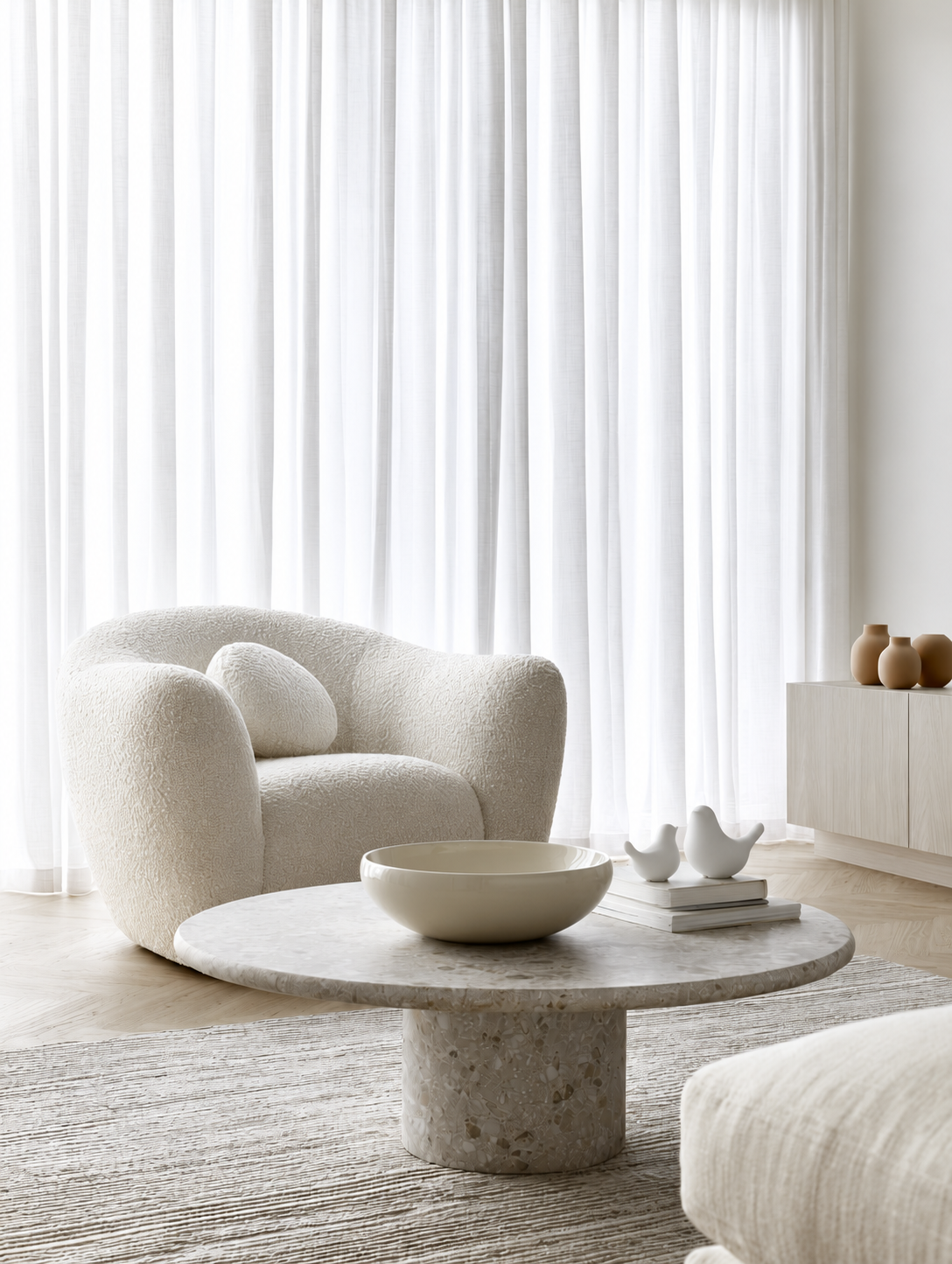 White Della ceramic doves on books on a terrazzo coffee table in a minimal living room