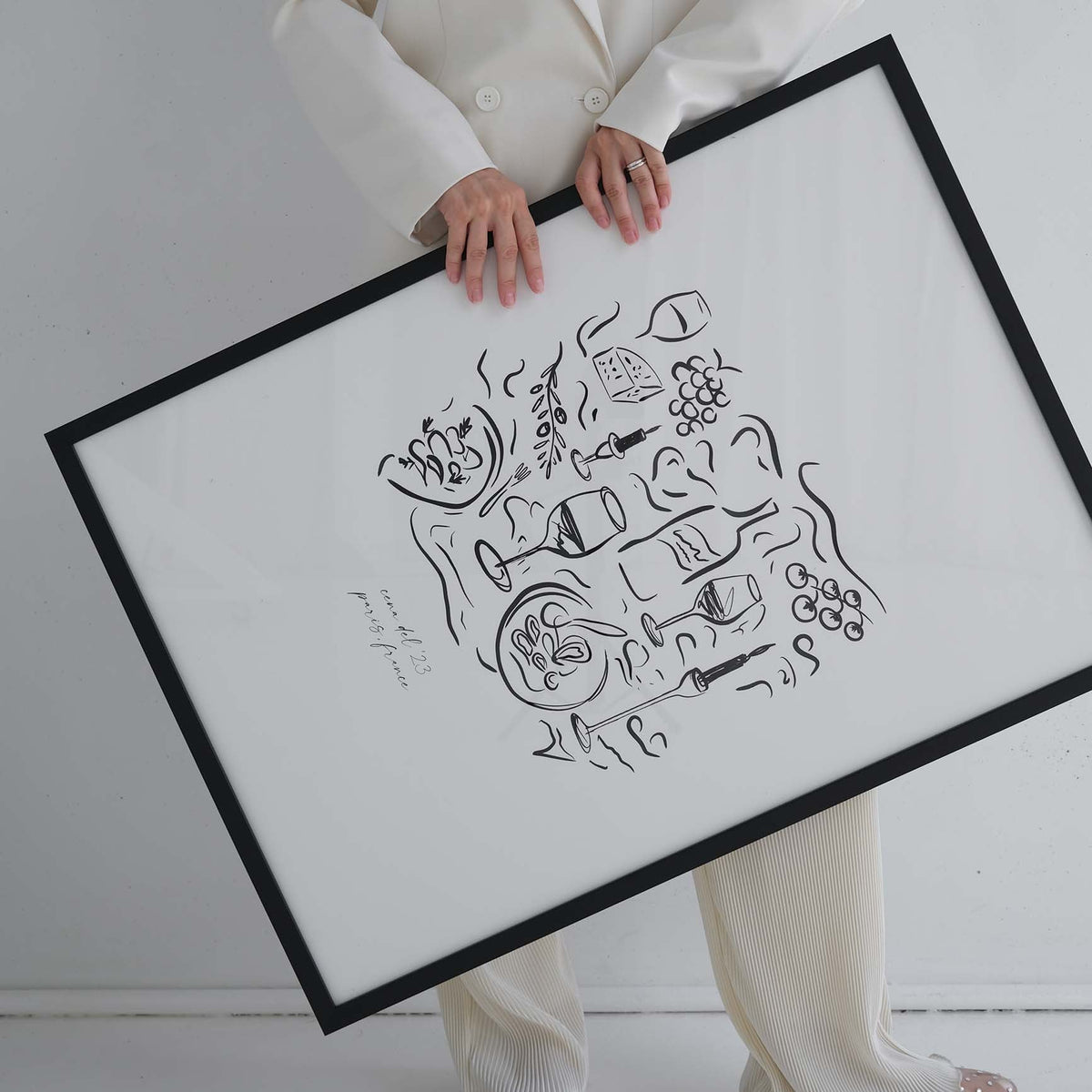 Woman carrying the Dinner Party print in a large black frame