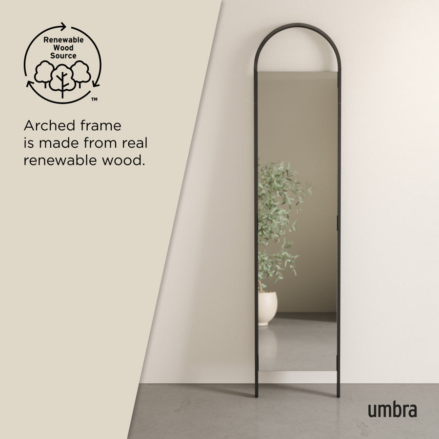 Umbra Bellwood leaning mirror in black, arched frame made from renewable wood