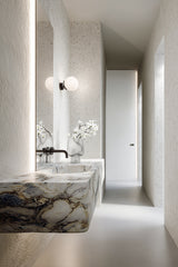 Artificial white dogwood spray styled in glass vase on marble vanity; realistic faux floral stem for home styling.