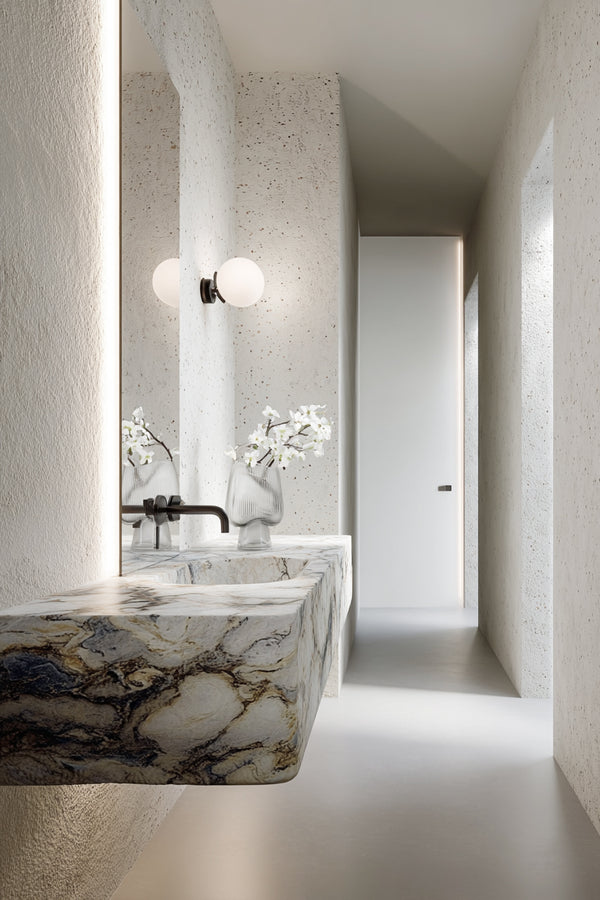 Artificial white dogwood spray styled in glass vase on marble vanity; realistic faux floral stem for home styling.