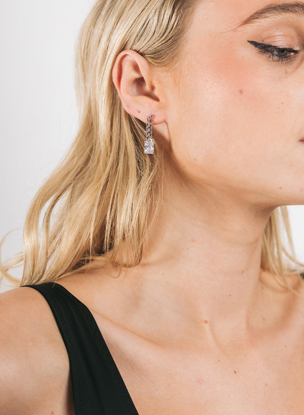 Dropping Stone Earring worn by a model in a black singlet, side profile