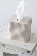 Ocean inspired 3D printed tissue box cover in neutral tone on Architectural Digest book