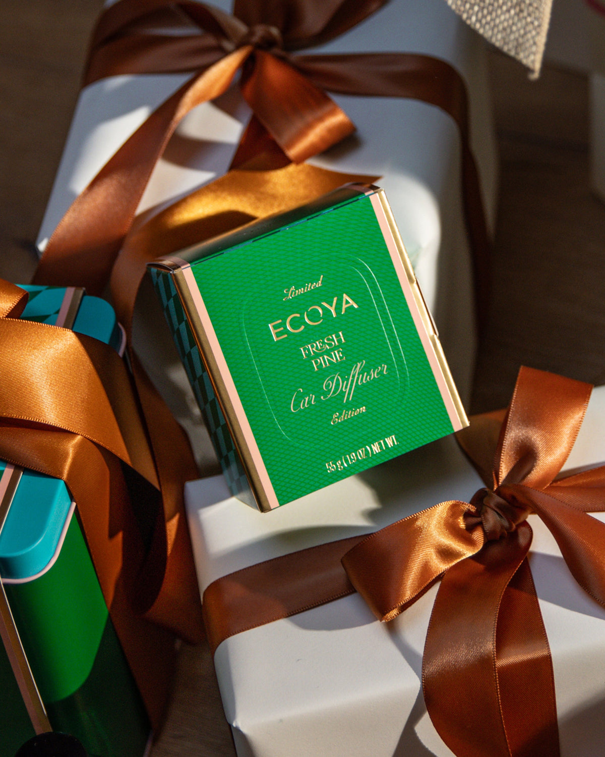 Ecoya Fresh Pine Car Diffuser gift box among presents tied with copper ribbon