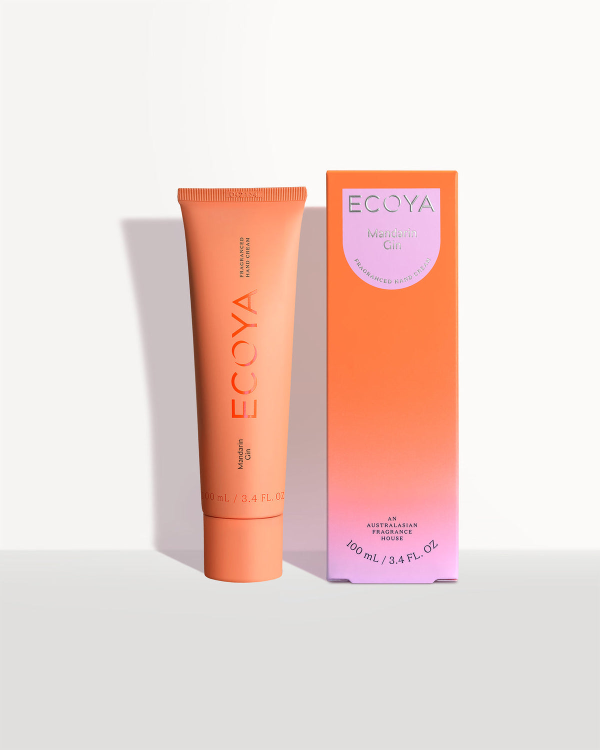 Ecoya hand cream in an orange tube beside its orange gradient box