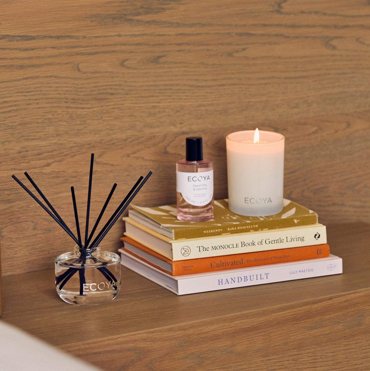 Ecoya Lotus Flower candle, room spray and reed diffuser styled on a stack of books