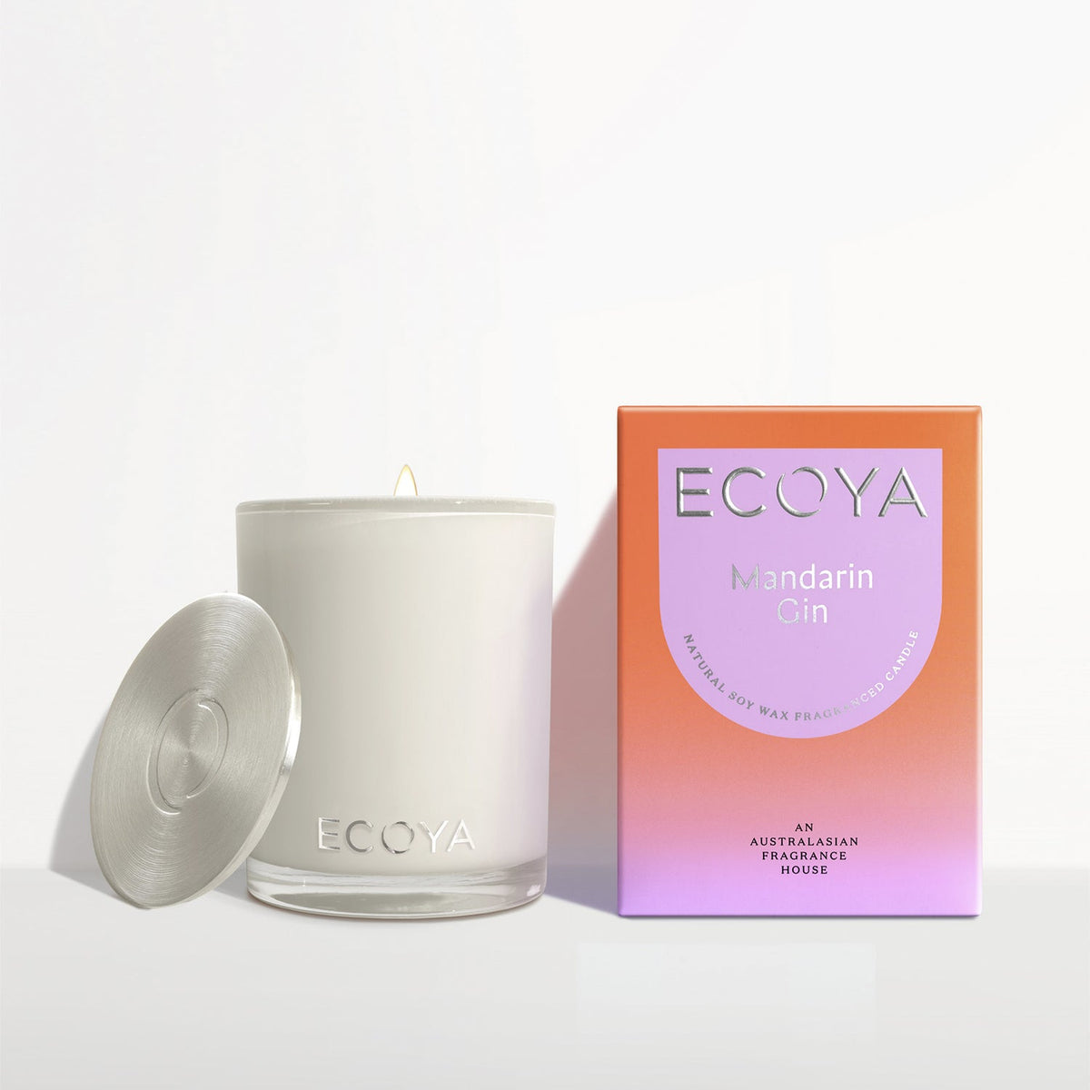 Ecoya Madison candle with the lid off beside its coral gift box