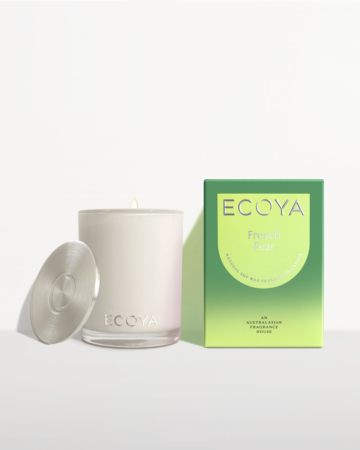 Ecoya Madison soy candle with its lid removed, shown beside its green French Pear gift box