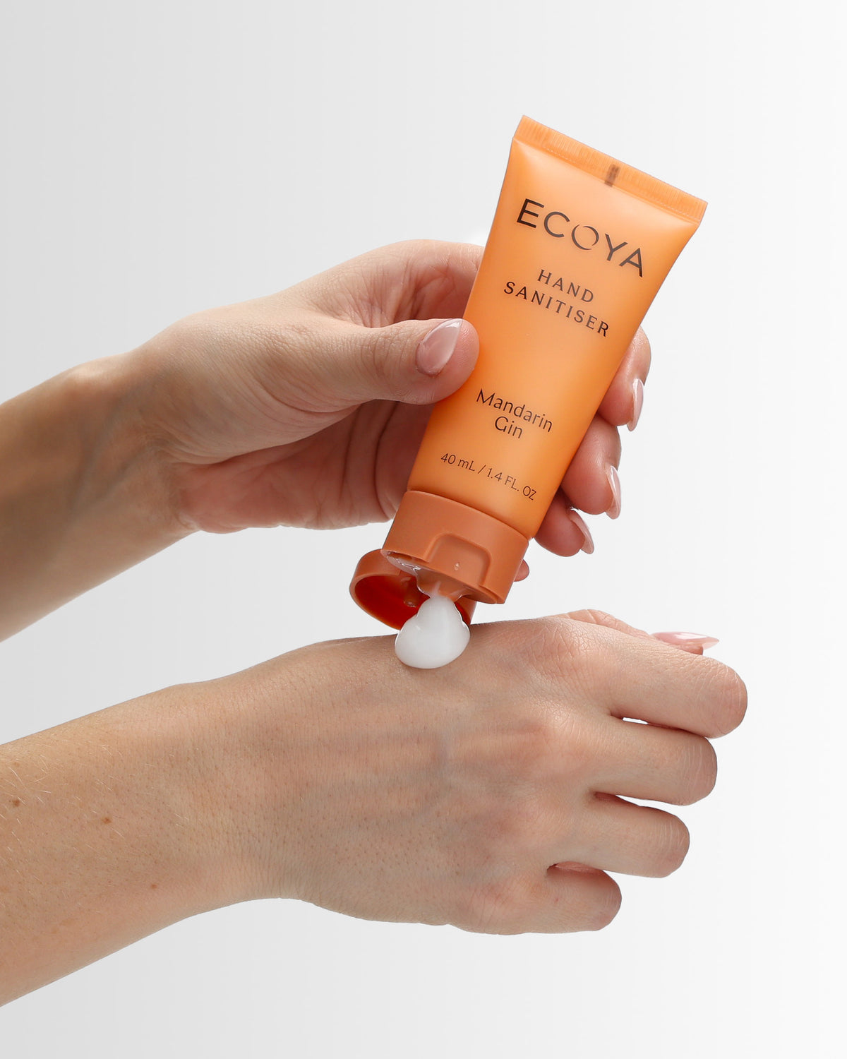 Hands dispensing Ecoya Mandarin Gin Hand Sanitiser from the 40ml travel tube