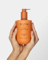Hands holding the Ecoya Mandarin Gin Hand Sanitiser 450ml pump bottle