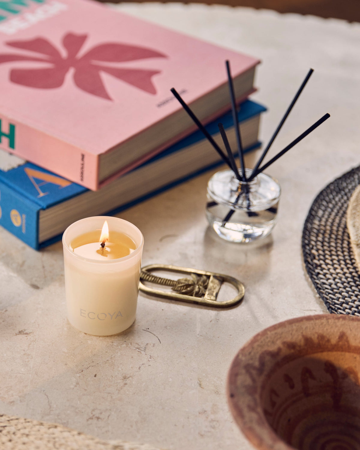 Ecoya Guava and Lychee Sorbet mini candle and reed diffuser styled on a table with books