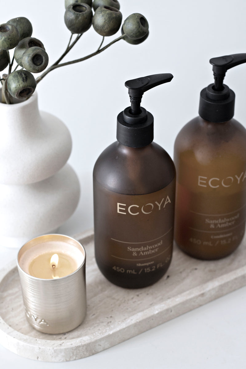Ecoya Sandalwood & Amber Shampoo & Conditioner set styled with candle – luxury haircare duo with nourishing oils