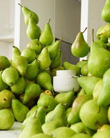 ECOYA French Pear Soy Wax Melter styled among fresh green Queensland pears referencing the French Pear fragrance.