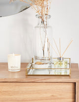 Ecoya Sweet Pea & Jasmine mini candle and diffuser styled on a wooden bedside table with a glass vase and mirrored tray.