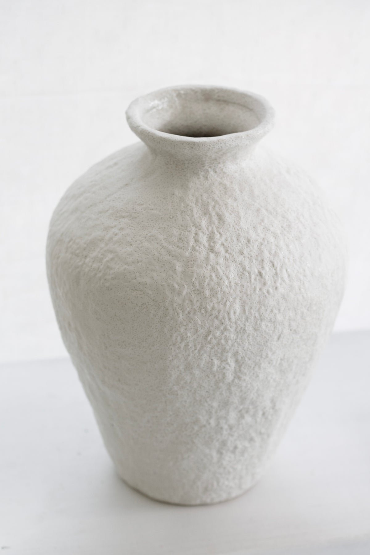 Lyra white vase on a pale surface in a bright, minimal room