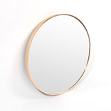 A sleek Bella Round Wall Mirror - 60 cm - Black / Brass / Chrome by Flux Home with a gold frame on a white surface.