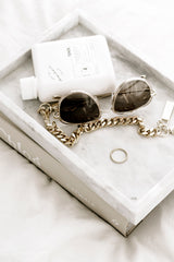Gold chain handle clip by Federation styled on marble tray with sunglasses