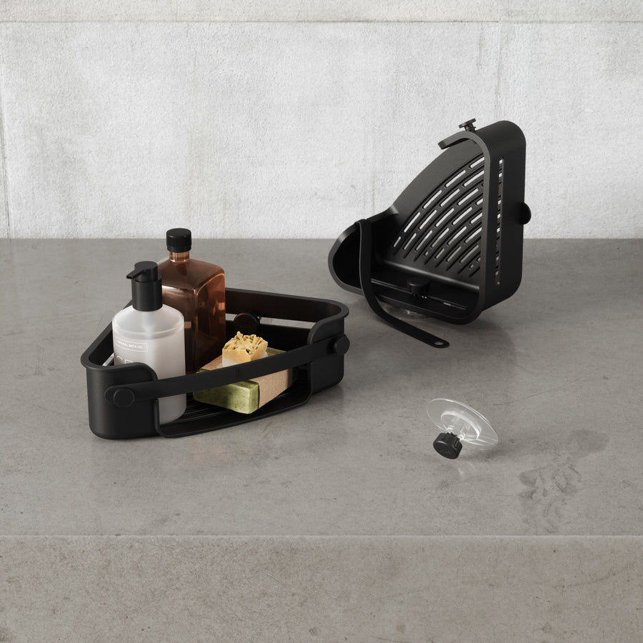 Umbra Flex corner bin in black with its drainage tray removed, adhesive disc beside it