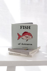 Fish of Aotearoa children’s board book by Kate Dickinson stacked on neutral books on white table