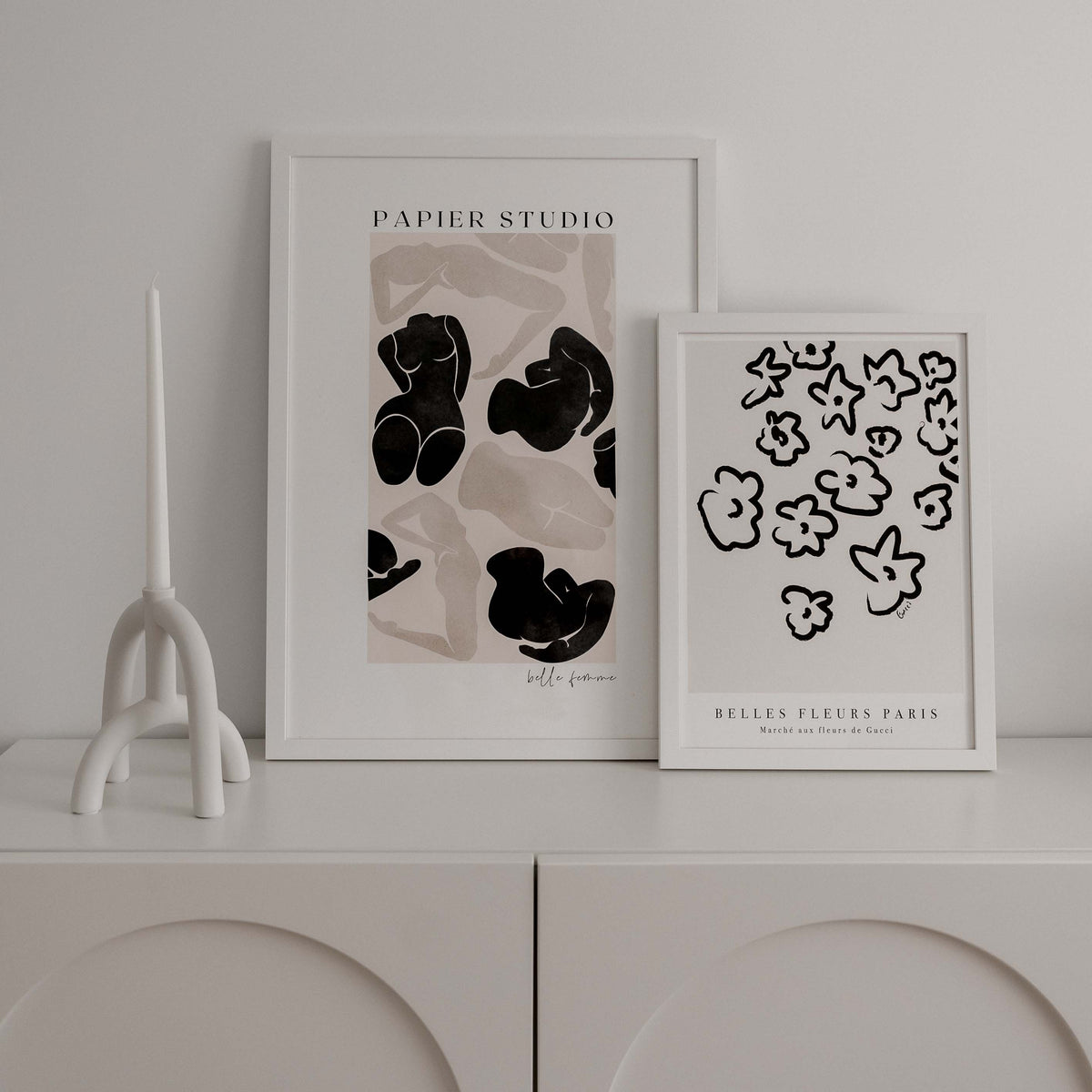 Close view of the Fleurs print framed beside the Belle Femme print on a white sideboard