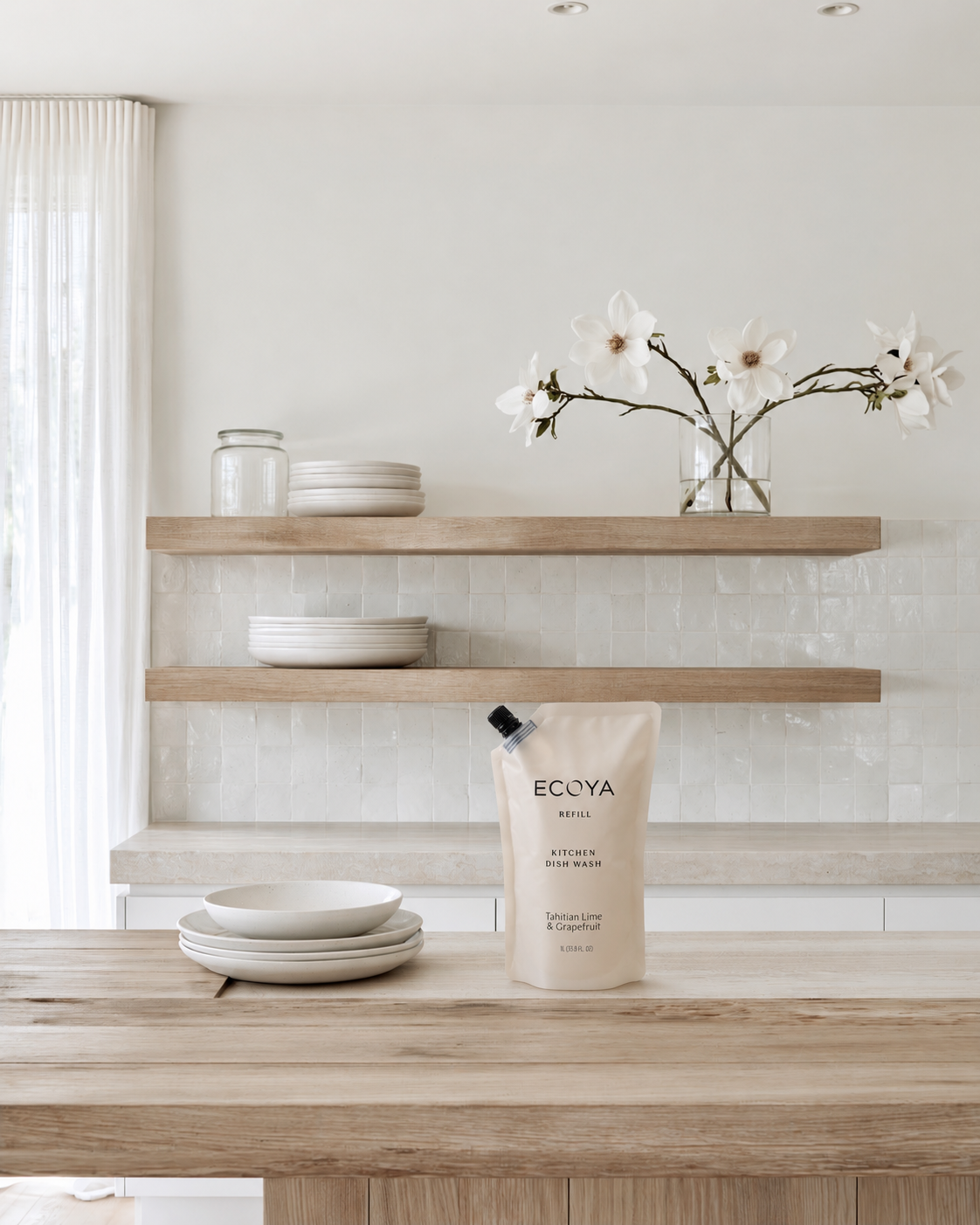 Ecoya Tahitian Lime & Grapefruit dish wash refill pouch on a timber island beside stacked plates