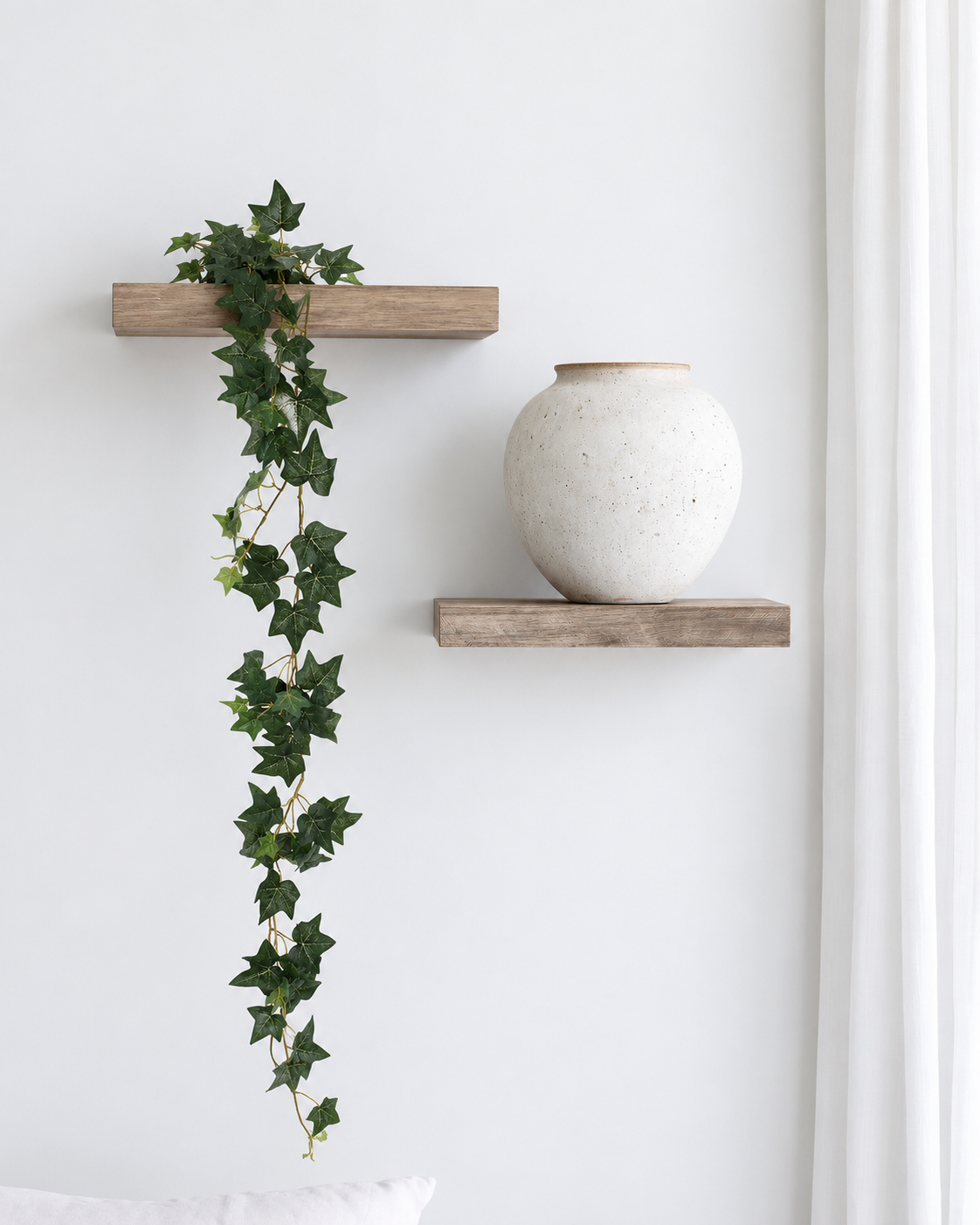Mini English ivy garland trailing from a floating wall shelf down the wall