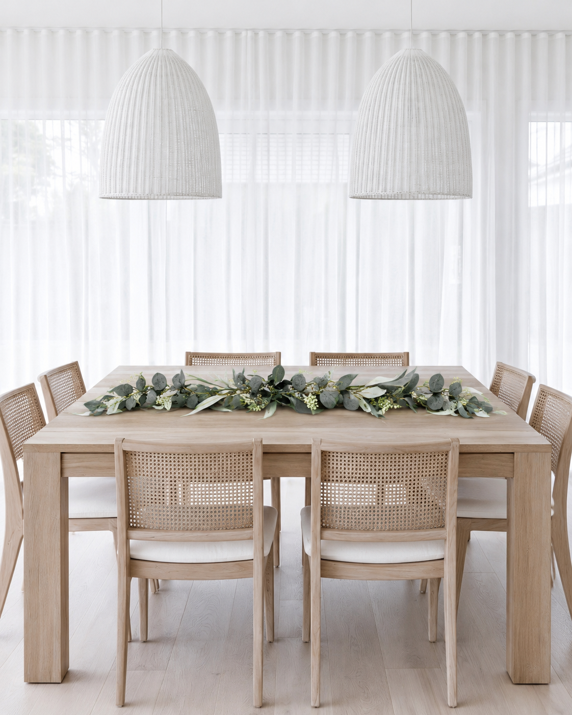 Seeded eucalyptus garland laid down the centre of a dining table as a table runner