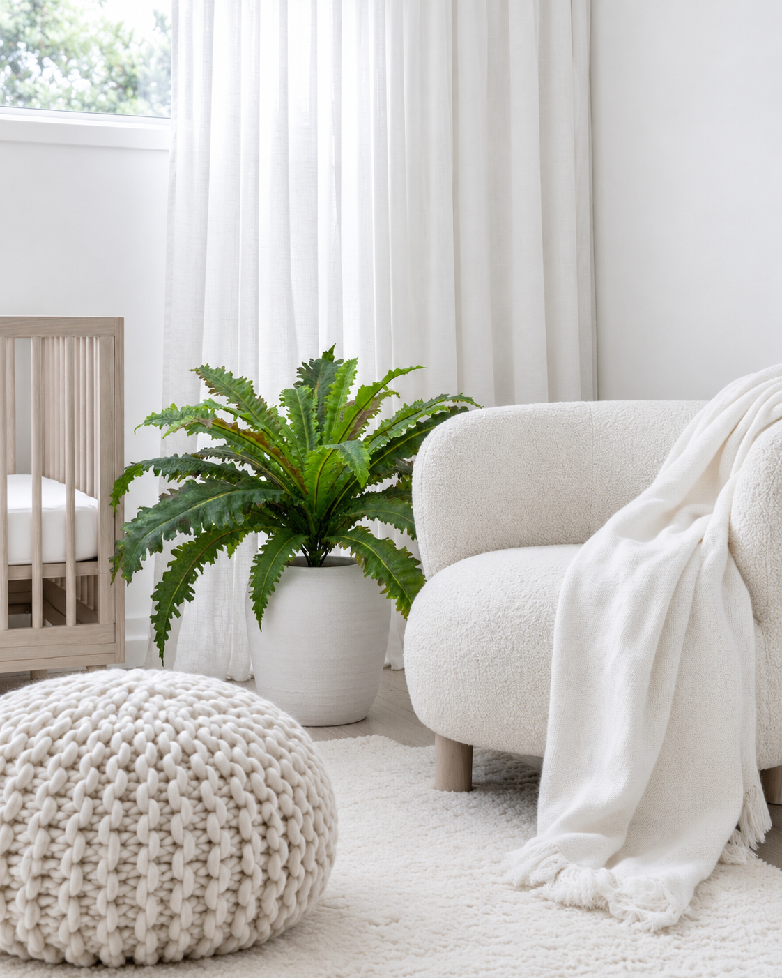 Margarintum fern bush in a white planter on the floor beside a boucle armchair
