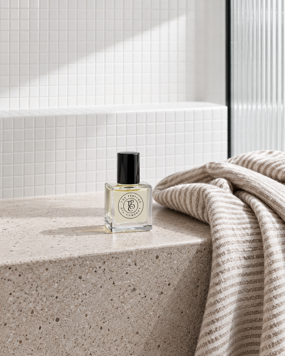 GYPSY Perfume Oil on a stone bench beside the folded towel