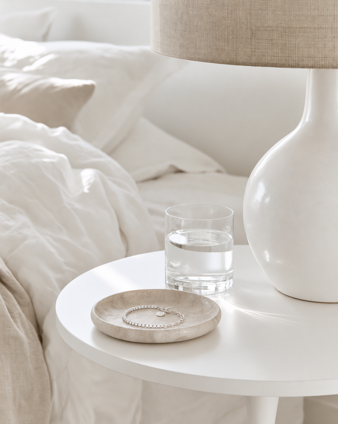 Federation Fifty Fifty Bracelet in sterling silver coiled in a stone trinket dish on a white bedside table