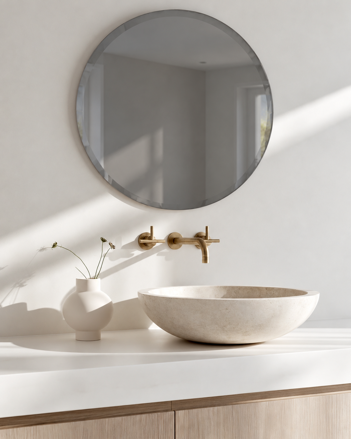 Umbra Bevy round smoke mirror above a stone vessel basin and brass tapware