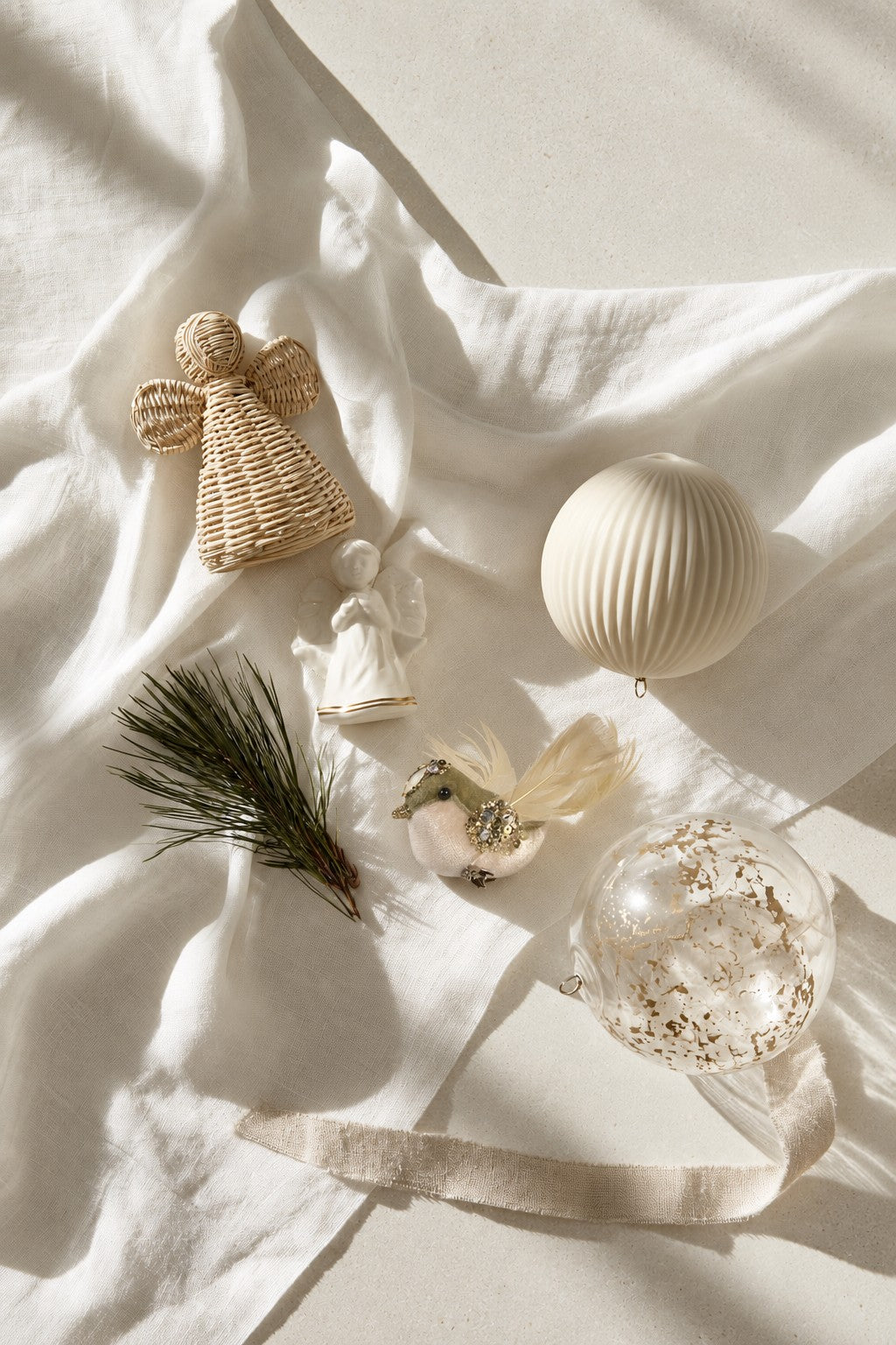 Moss green finch chick decoration on white linen with rattan and porcelain angels and two baubles
