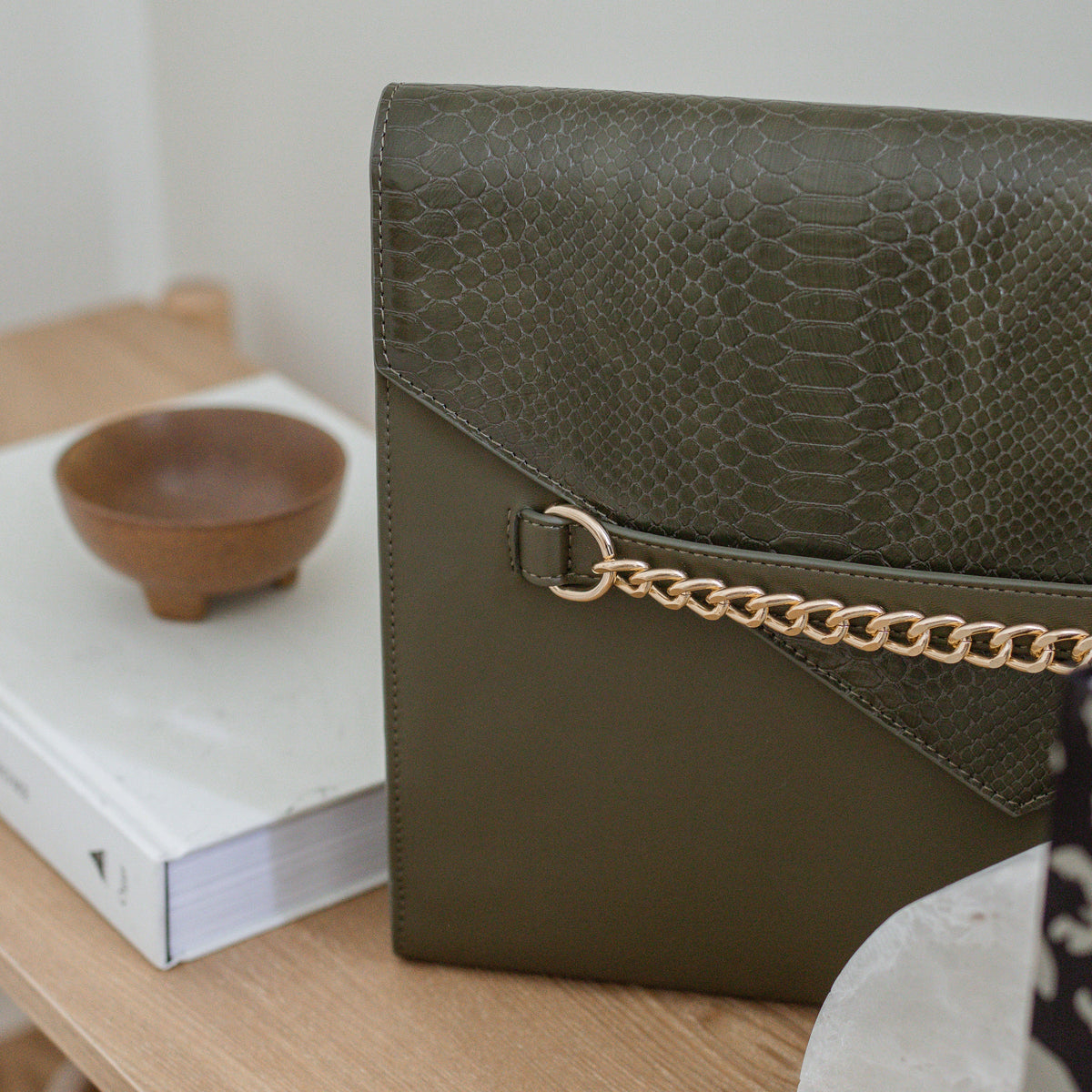 Forest Green laptop sleeve standing beside a wooden bowl