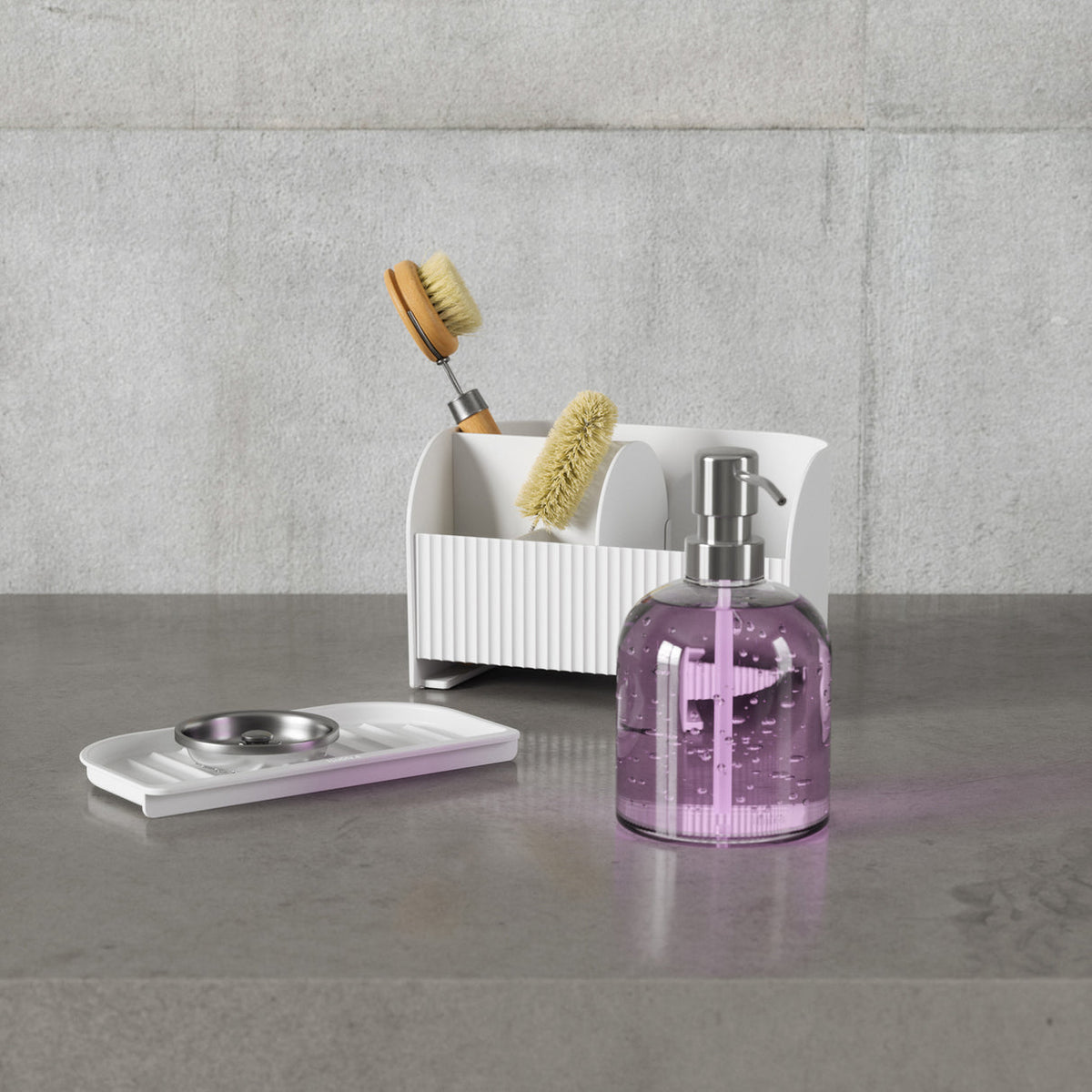 Umbra Sling sink caddy in white holding a soap pump, brush and sponge