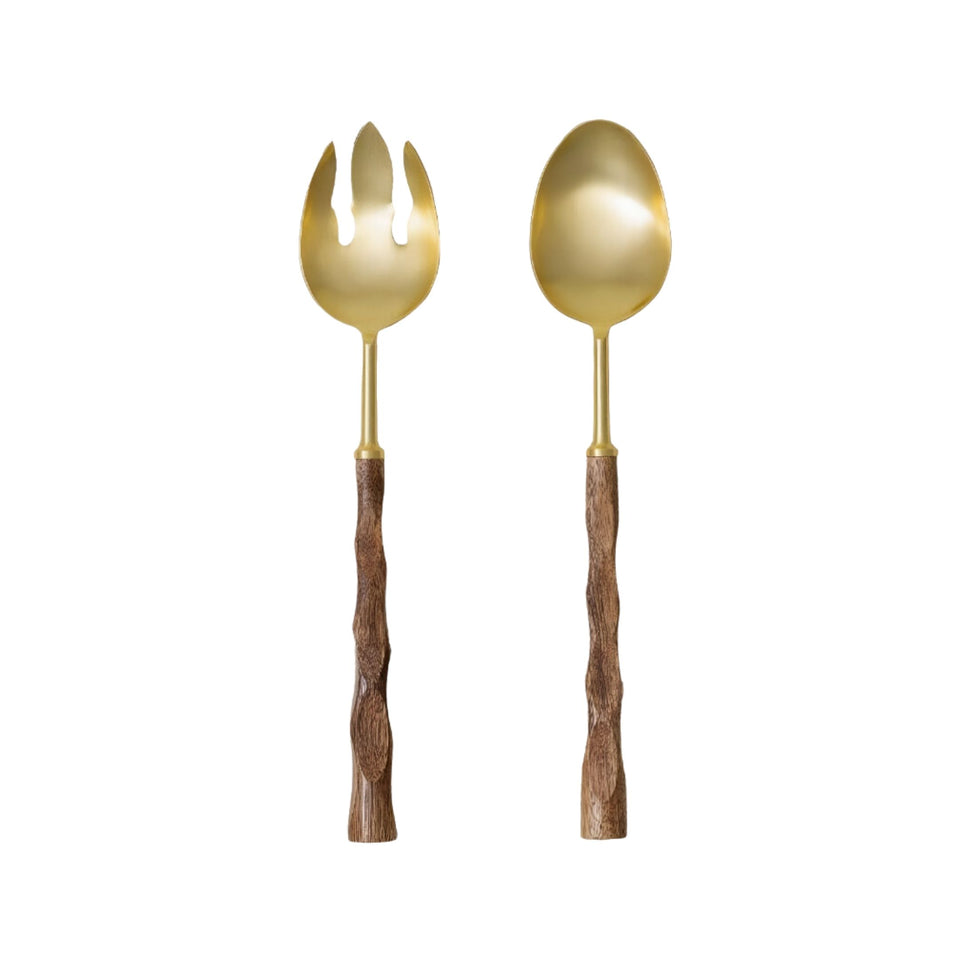 Gold and wood salad servers styled on a dining table with serving bowls